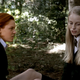Two girls in boarding-school uniforms sit and talk in horror movie The Woods.